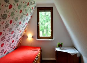 维滕贝克Finnhütte von Mai bis September的一间卧室设有红色的床和窗户。