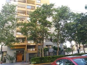 圣地亚哥Edificio Villaseca的公寓大楼前面有树木