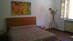 诺利Via dei Ginepri的卧室配有一张床,墙上挂有绘画作品