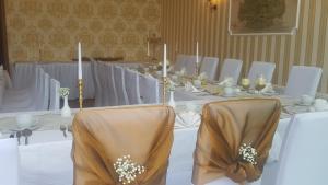 PeitzGasthaus Schillebold的一张长桌,配有白色的桌子、椅子和蜡烛