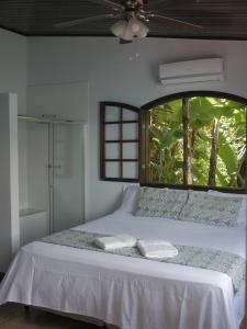 Praia de PalmasPousada Toca do Mar的卧室配有白色的床和窗户