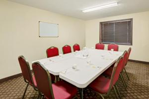 道奇堡道奇堡戴斯酒店的一间会议室,配有白色的桌子和红色的椅子