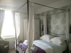 埃文河畔斯特拉特福Winton House的一间卧室设有天蓬床和窗户。