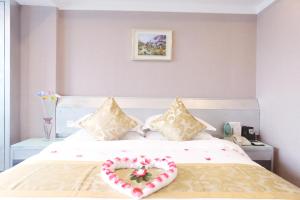 广州广州颐和商务酒店的一间卧室配有一张心形枕头的床