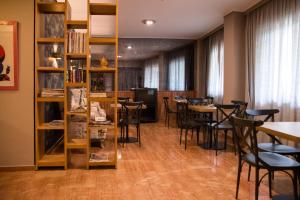 雅典马罗西酒店的配有桌椅和书架的房间