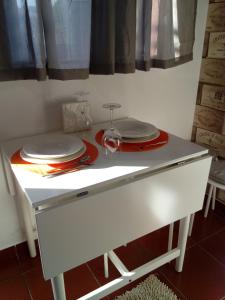 阿马兰特Casa da Vovó (Casa do Tapado)的一张带盘子和酒杯的白色桌子