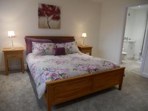 康福斯8 Swan House的卧室内的一张床位,配有两张桌子和两盏灯
