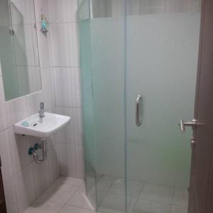 万隆秀波莱特2号公寓的一间带玻璃淋浴和水槽的浴室
