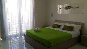 切萨雷奥港B&B La Laguna的一间卧室配有一张绿床,上面有泰迪熊