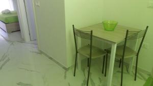 切萨雷奥港B&B La Laguna的一张小桌子,上面有两把椅子和碗