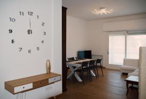 特雷维索La Maison di Laura的客厅配有桌子和墙上的时钟