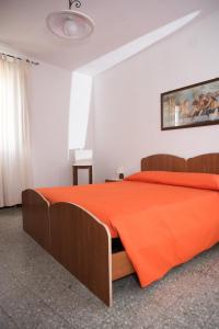 维拉普特祖Green House的一间卧室配有一张带橙色毯子的床