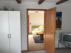 古梅尔斯巴赫历史公寓的通往卧室的门,卧室配有一张床和电视