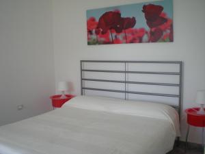 马拉泰亚Villa Manatí的一间卧室配有白色的床和两张红色的桌子
