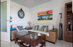 滨海罗克塔斯Playa Serena Mar y Golf gran terraza的客厅配有沙发和墙上的时钟
