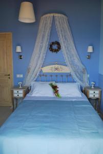 苏卡雷斯Thea Thalatta Villas的蓝色卧室设有一张带蓝色墙壁的大床