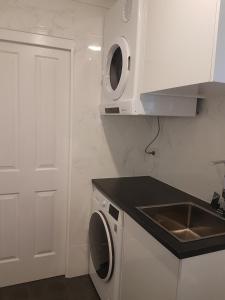 GlenwoodEdwin Place Apartment的白色的厨房配有水槽和洗衣机