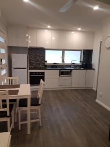 GlenwoodEdwin Place Apartment的厨房配有白色橱柜和桌椅