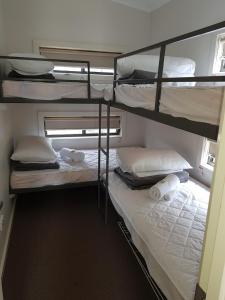 亚勒旺加Yarrawonga Riverlands Tourist Park的一间卧室配有两张双层床,提供白色的床单和毛巾