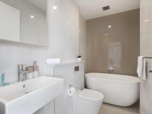 悉尼As the Sun Sets - Modern and Spacious 2BR Zetland Apartment Facing the Setting Sun的白色的浴室设有卫生间和水槽。