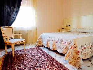 奥尔贝泰洛丽思特兰特韦基亚马雷玛酒店的卧室配有床、椅子和窗户。