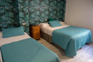 两姐妹蒙诺酒店的配有两张蓝色和绿色壁纸的客房