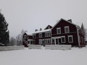 KauhajokiSuvannonrannan Majoitukset的一座大黑房子,地面上积雪