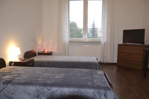 华沙Warszawa Stare Bielany的酒店客房设有两张床和电视。
