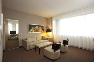 柏林柏林亚历山大广场H4酒店 的带沙发和椅子的客厅以及窗户。