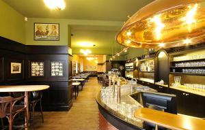 帕尔杜比采曼陀罗草公寓的餐厅设有酒吧,配有桌椅