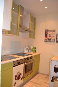 吕格德Ferienwohnung Holland 5a的厨房配有绿色橱柜和炉灶。 顶部烤箱