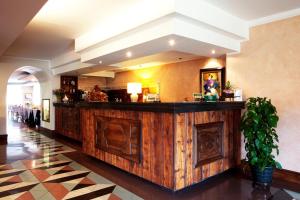 奥斯塔Hotel Diana Jardin et Spa的大堂内的餐厅设有大型木制酒吧