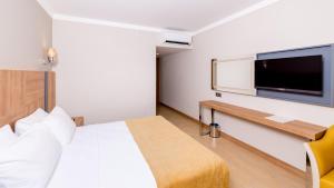 马尔马里斯朱利安俱乐部酒店的配有一张床和一台平面电视的酒店客房