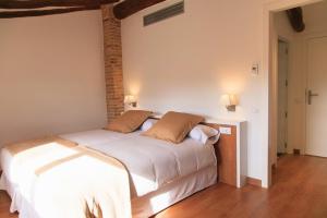格拉塔略普斯Clos Figueras的卧室配有一张带两个枕头的大白色床