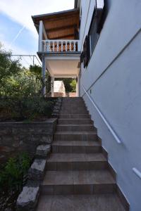 格迪恩赫Apartmani Marko的楼梯通往带阳台的房子