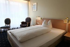 慕尼黑安比恩特甘尼酒店的酒店客房,配有一张床和两把椅子