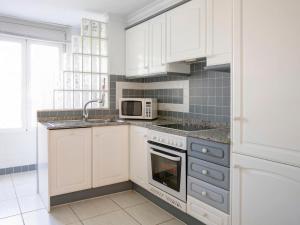 Casas DevesaApartment Keops by Interhome的厨房配有白色橱柜、水槽和微波炉