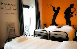 蓬塔德尔加达Azores Dream Hostel的墙上壁画的房间里设有两张床