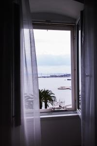 斯普利特Luxury rooms Skystar-Split的窗户享有水景,配有酒杯
