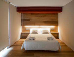 奥洛特车站酒店的卧室配有一张白色大床和木墙
