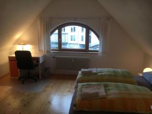 弗莱堡尚沃德豪斯的一间卧室设有两张床、一张桌子和一个窗口。