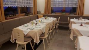 科瓦拉因巴迪亚Garni Margherita的餐厅的一排桌子,有白色桌布