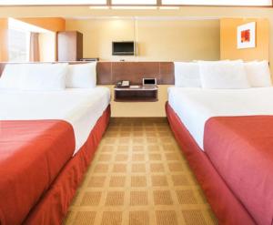 斯蒂尔沃特Microtel Inn by Wyndham Stillwater的酒店客房设有两张床和电视。