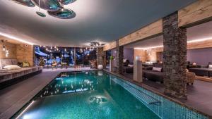 奥蒂塞伊Alpin Garden Luxury Maison & SPA - Adults Only的游泳池位于带客厅的客房中间