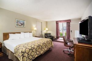约翰逊城约翰逊城贝蒙特套房酒店的配有一张床和一台平面电视的酒店客房