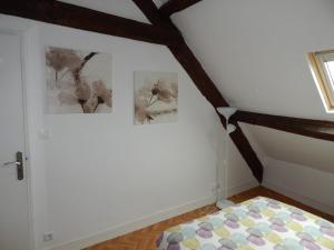 贝叶Au cœur du centre historique的卧室配有两张墙上的照片和一张床