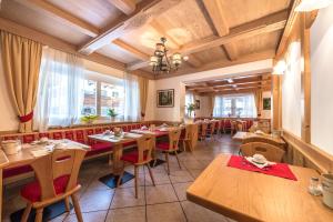 坎皮泰洛迪法萨Garni Tyrolia的餐厅设有木桌和红色椅子
