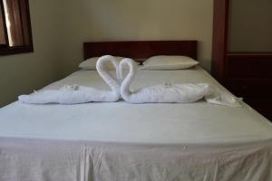 塔拉波托Tengana Hospedaje y Tours的两条毛巾,形状像天鹅,坐在床上