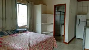 圣佩德罗塞拉Chalé em São Pedro da Serra - Nova Friburgo的一间卧室设有一张床、一个窗口和一台冰箱