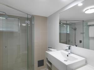 卡伦德拉Oaks Sunshine Coast Oasis Resort的白色的浴室设有水槽和淋浴。